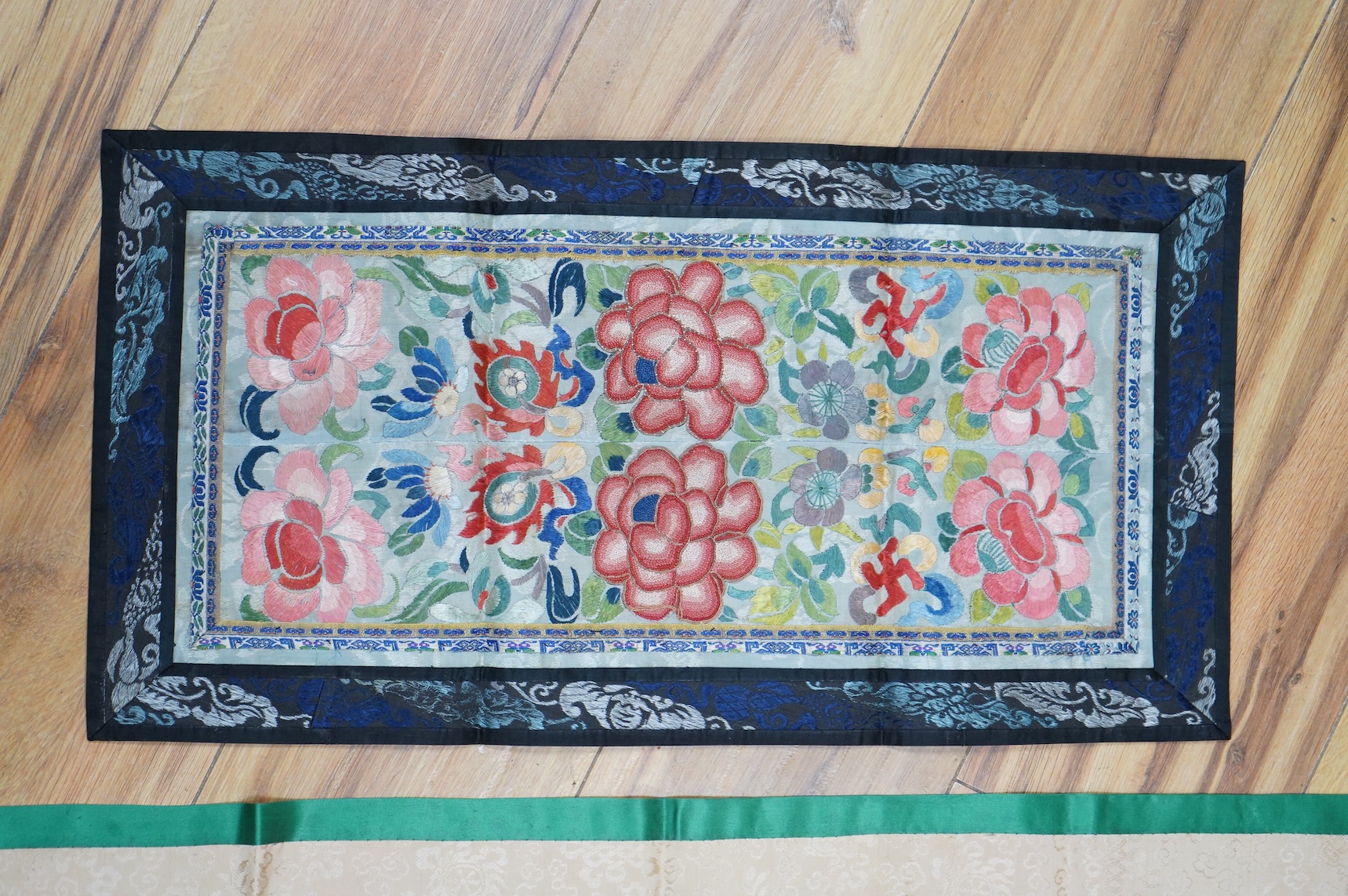 Two pairs of Chinese late 19th / early 20th century polychrome silk embroidered sleeve bands, now converted into two decorative table runners, one embroidered with large flowers using Peking knot, the other heavily embro